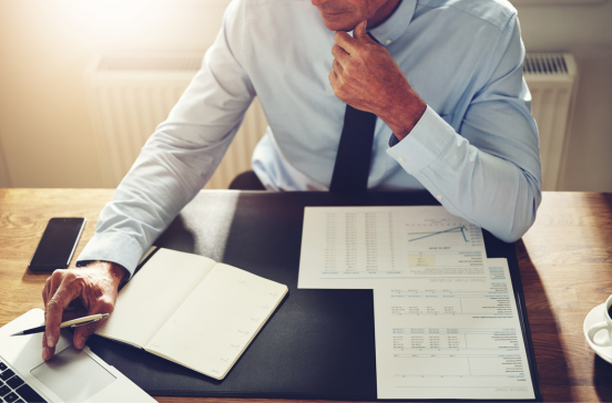 A businessman at a desk reviewing financial documents.