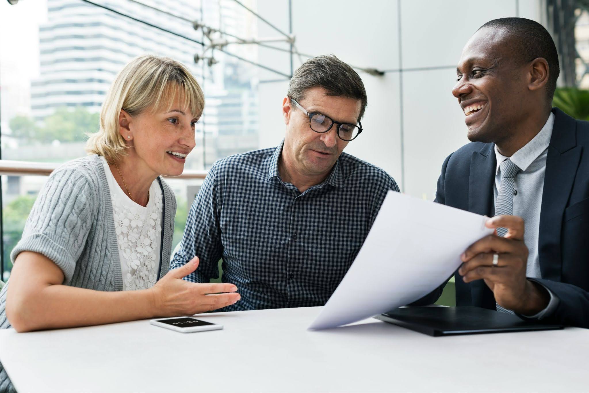 Couple reviewing retirement account paperwork with a financial professional during a planning meeting.